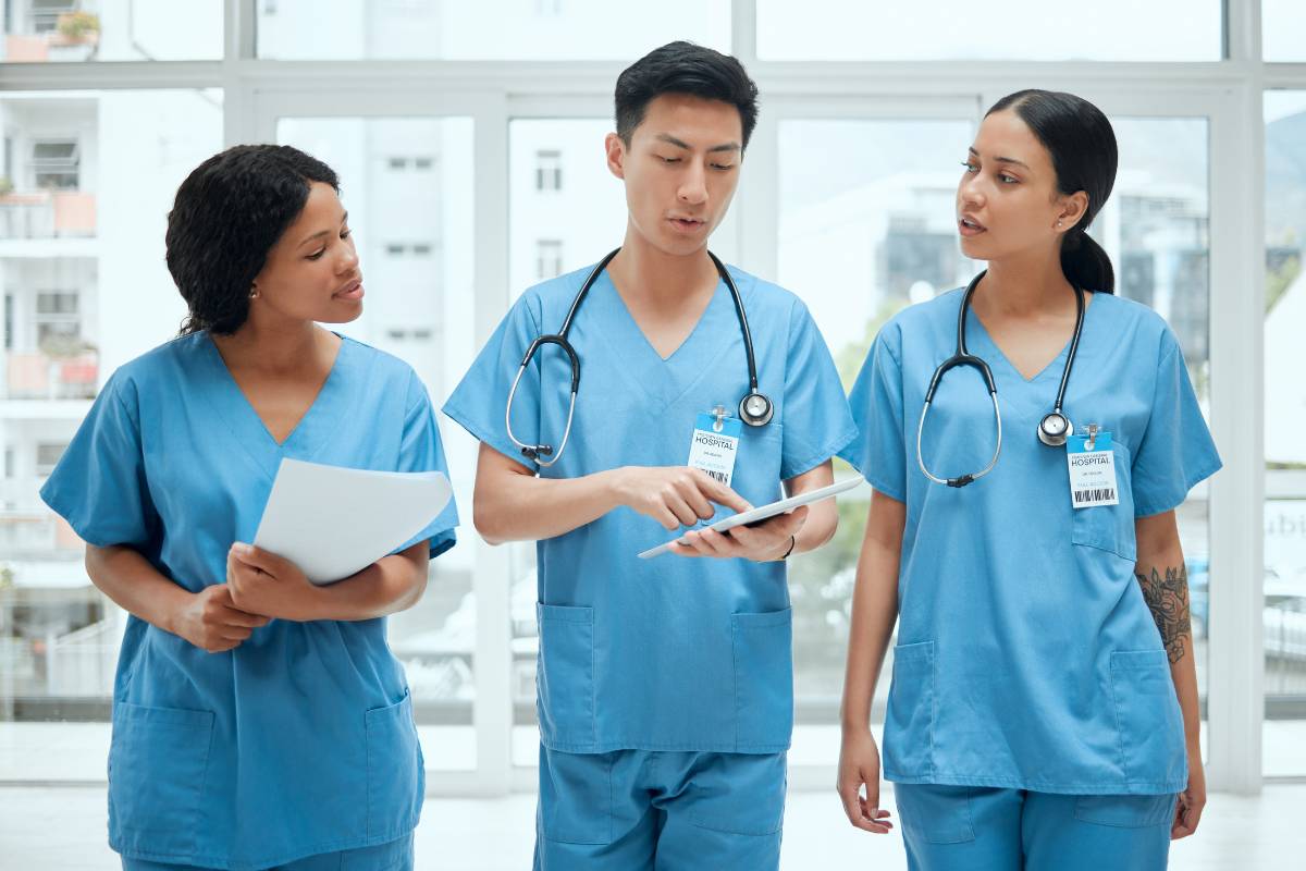 A man shows his clinical nurse specialist cover letter to colleagues.