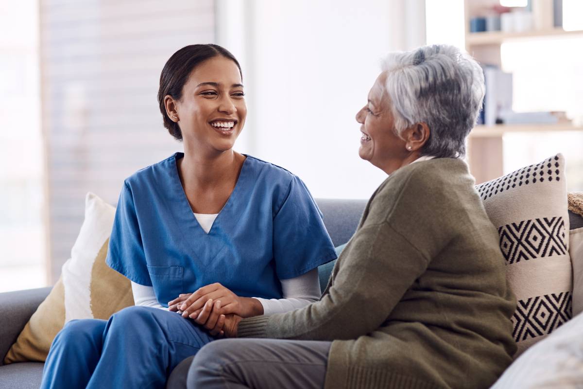 A nurse sits with a patient and displays culturally congruent care.