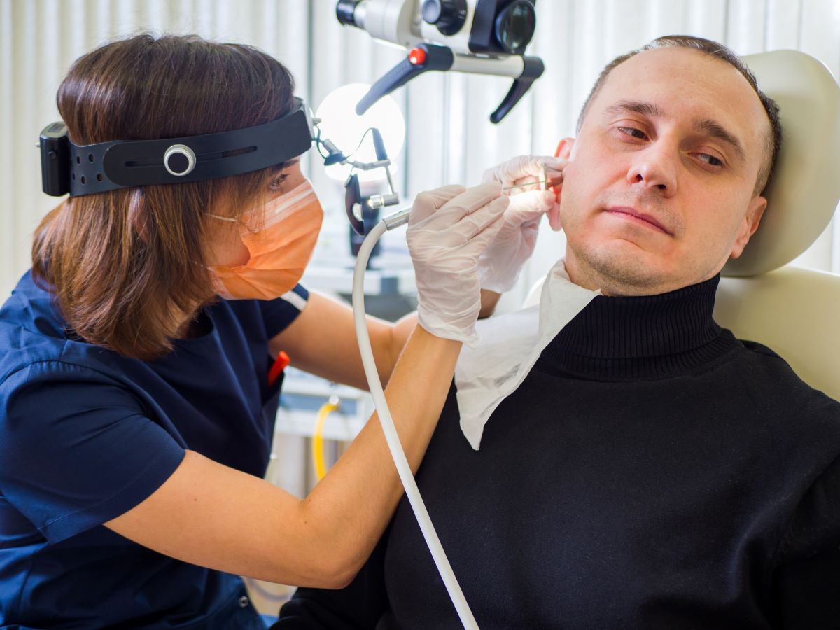 An ENT nurse checks a patient's ear.