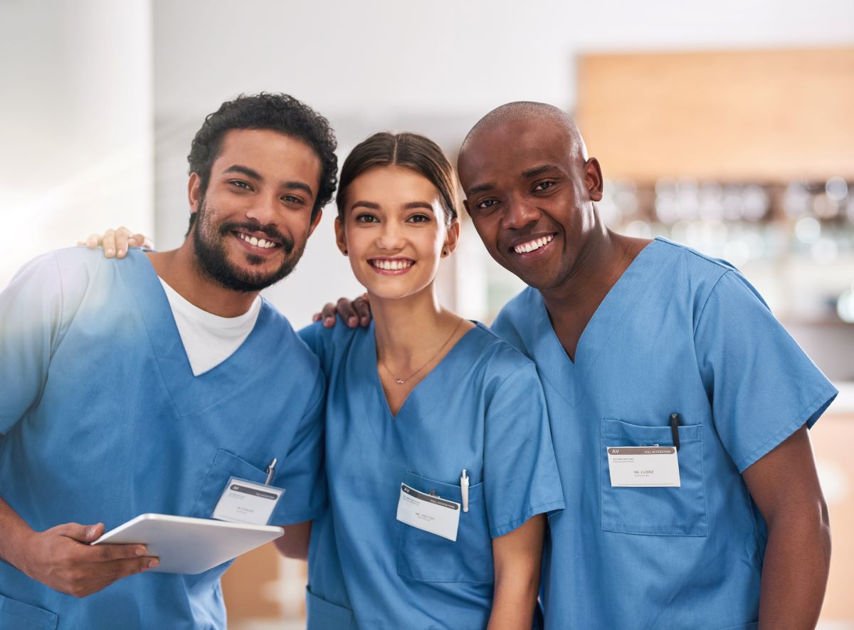 Three nurses, smiling at the camera.