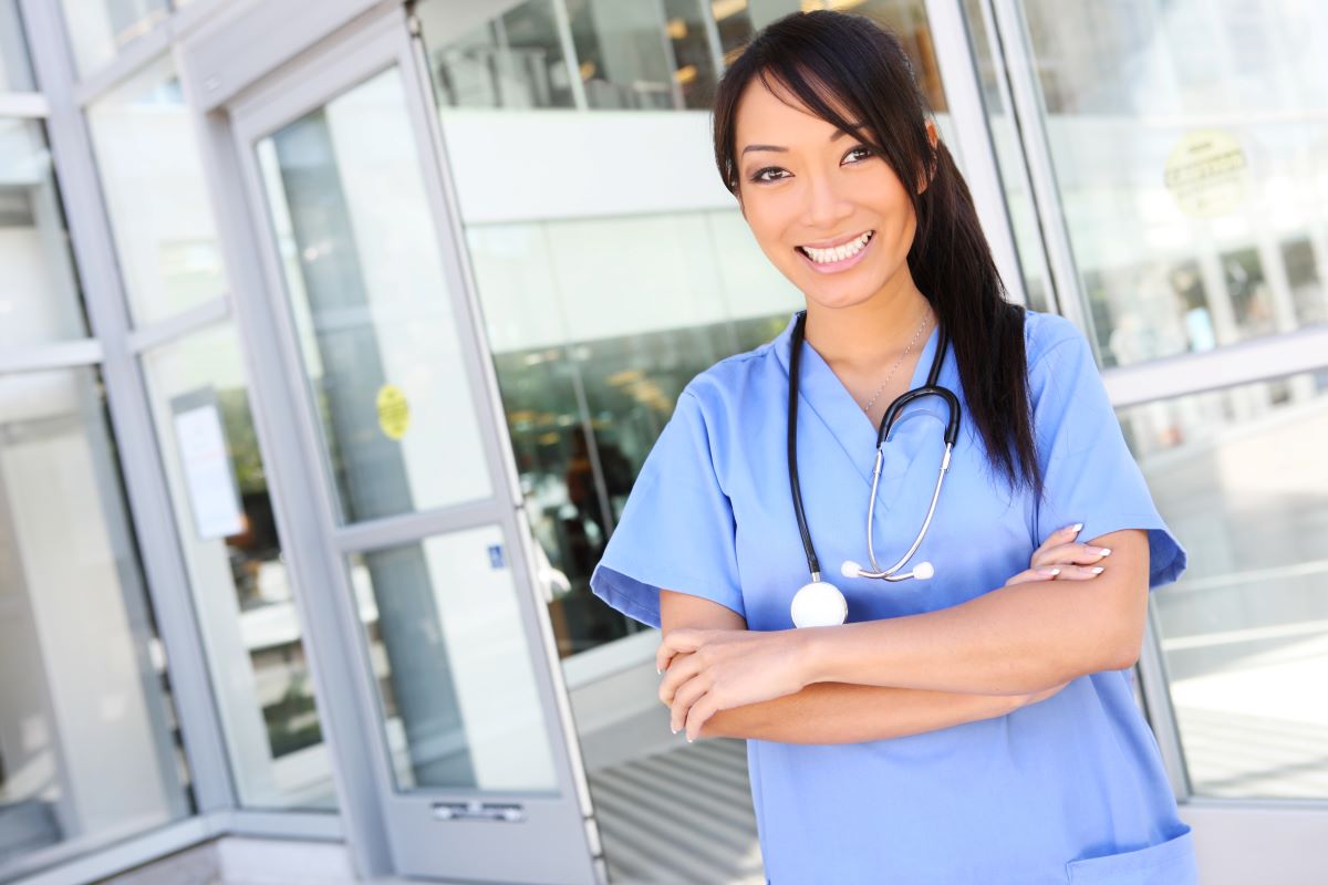 Nursing professional standing at the entrance of a magnet hospital facility
