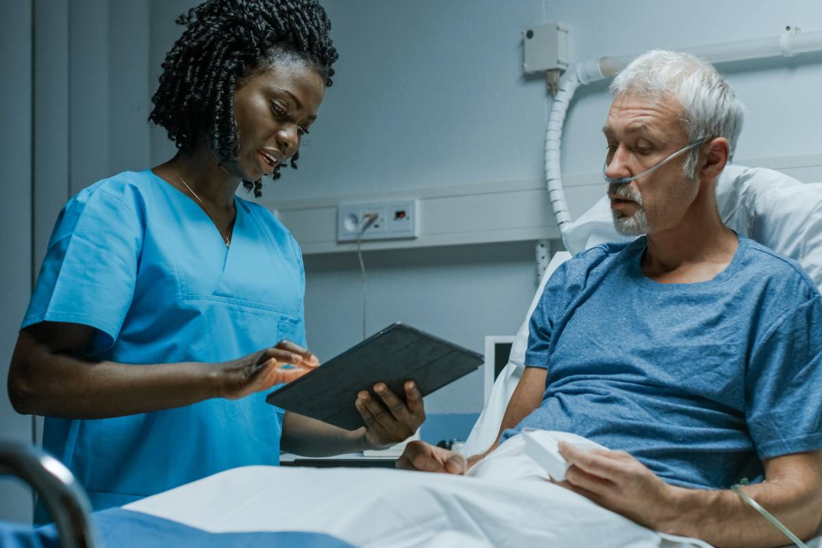 A nurse displays veracity in nursing by explaining a procedure to a patient.