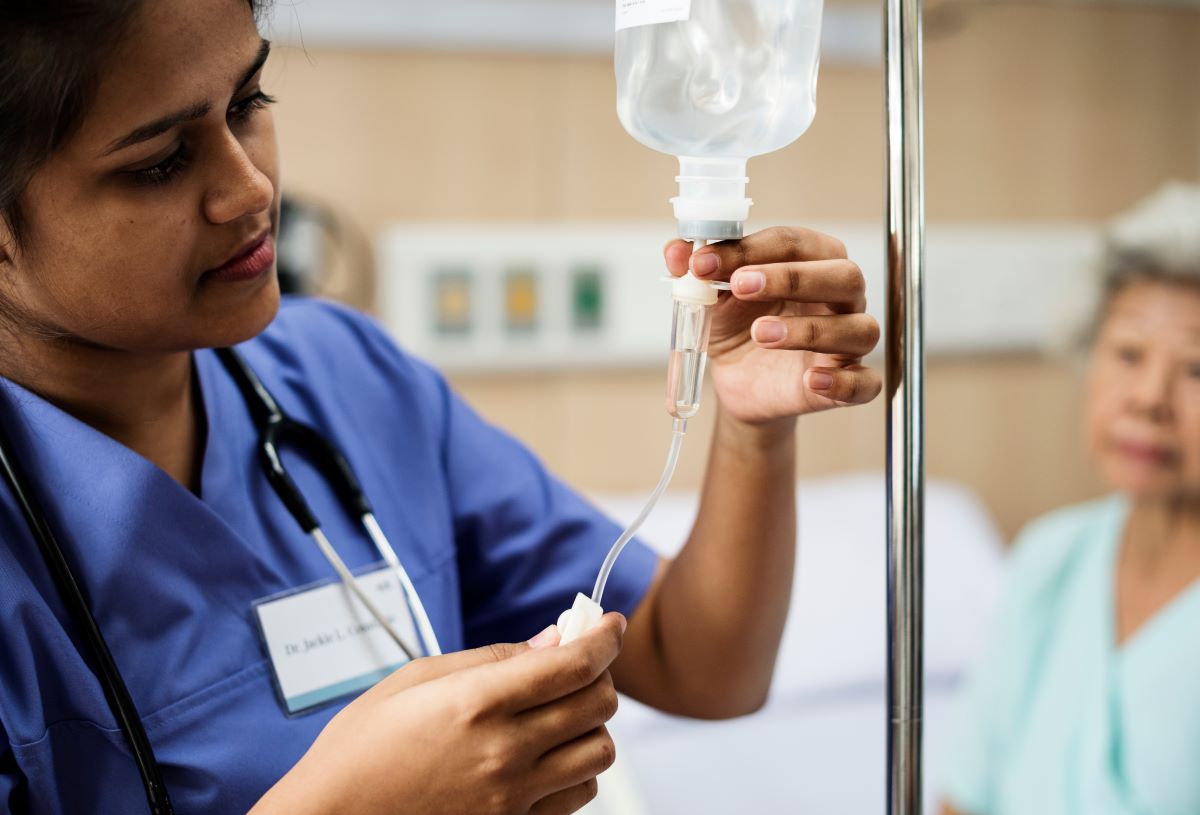 An infusion nurse prepares an IV drip for a patient.