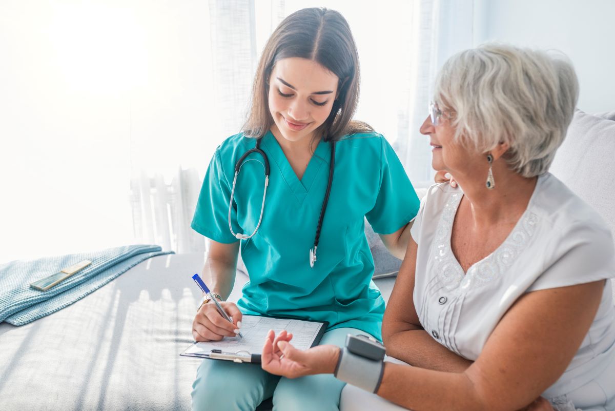 A nurse checks a resident's blood pressure and writes down the results.