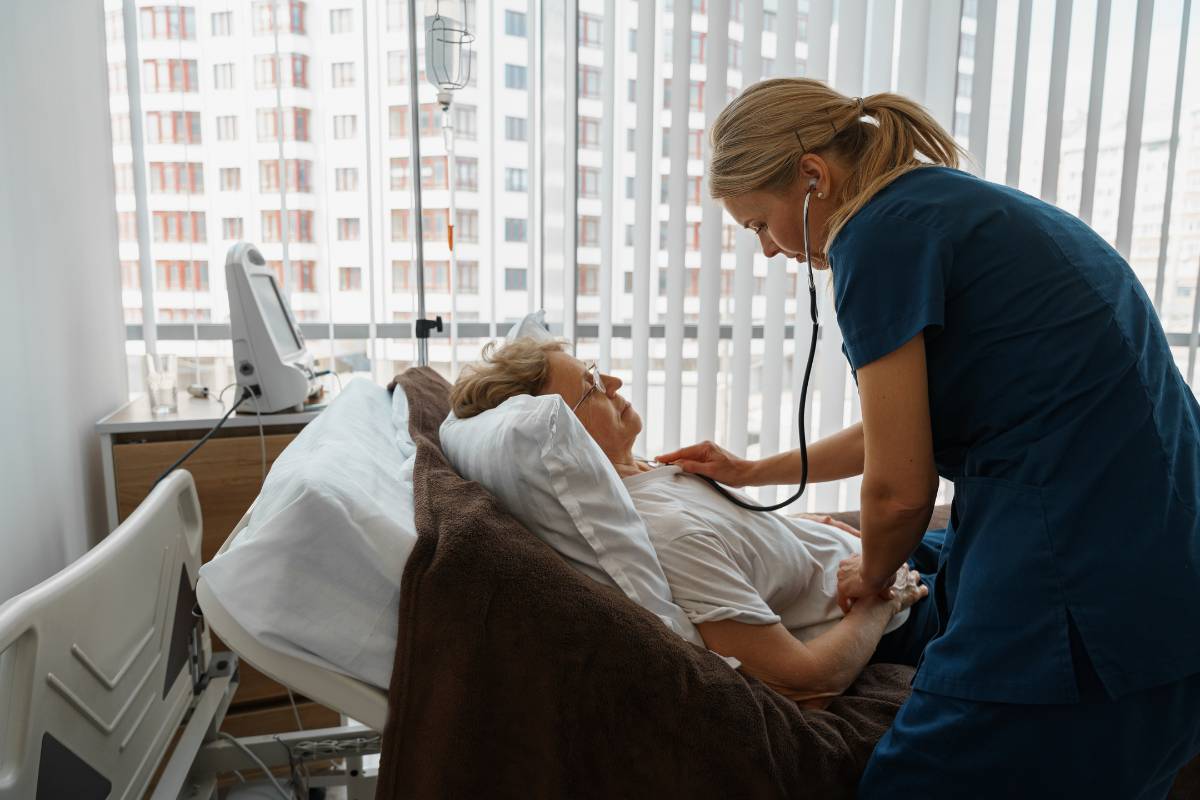 A cardiac nurse practitioner listens to a patients heartbeat.