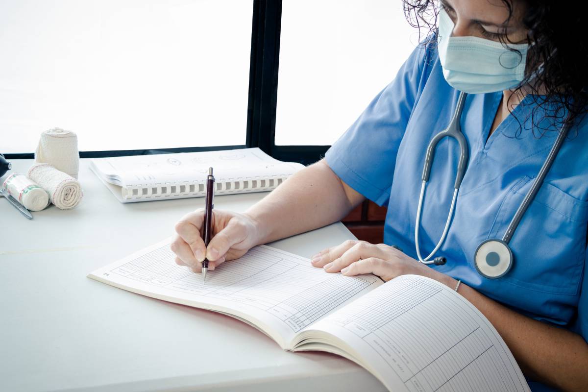 A nurse writes down information from the NANDA nursing diagnosis list.
