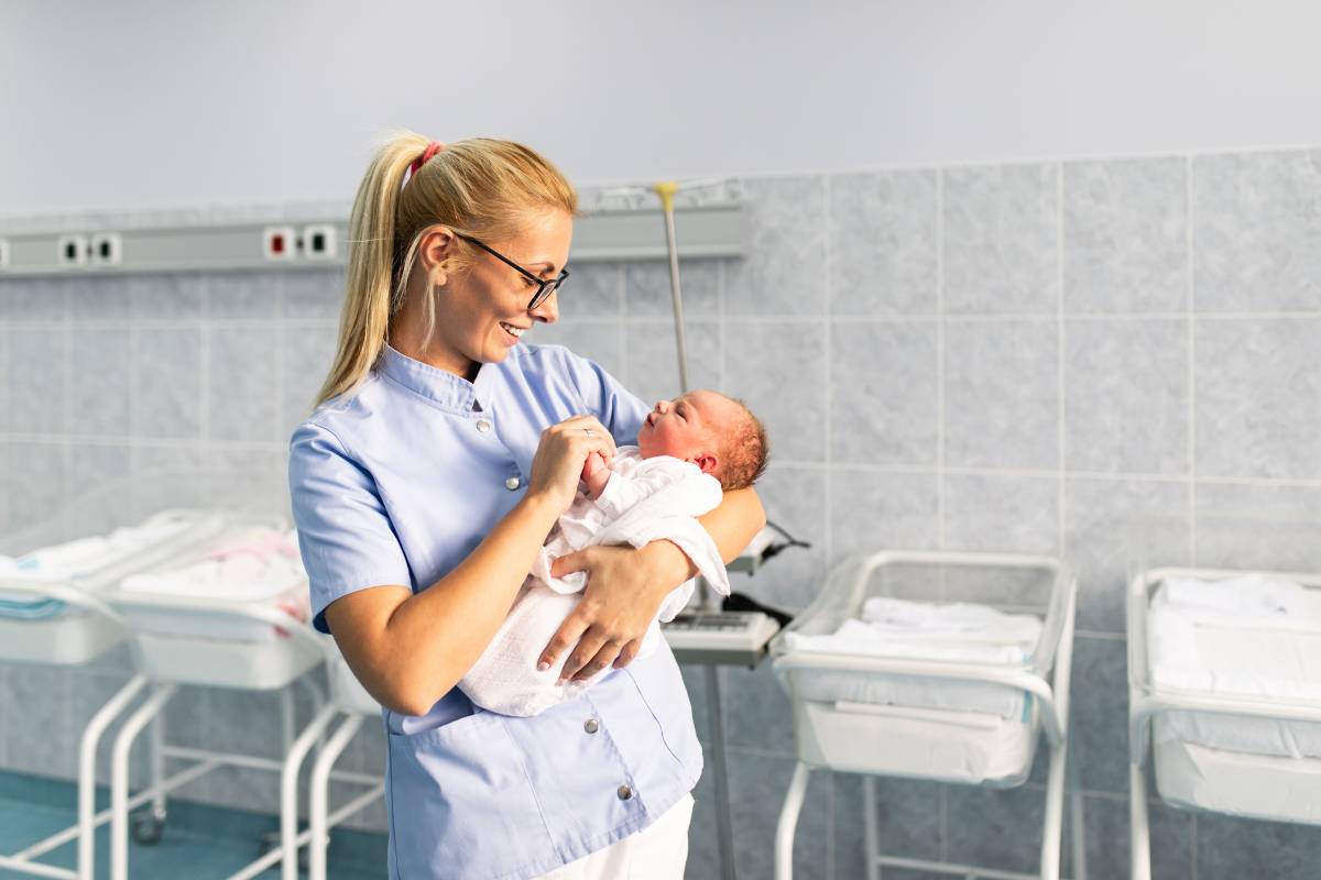 A nurse with NRP certification cares for an infant.