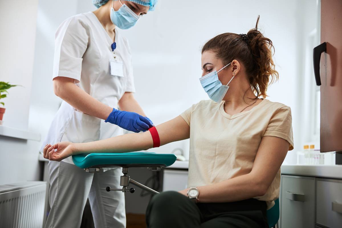 A nurse draws blood and explains the distinction between phlebotomy license vs. certification.