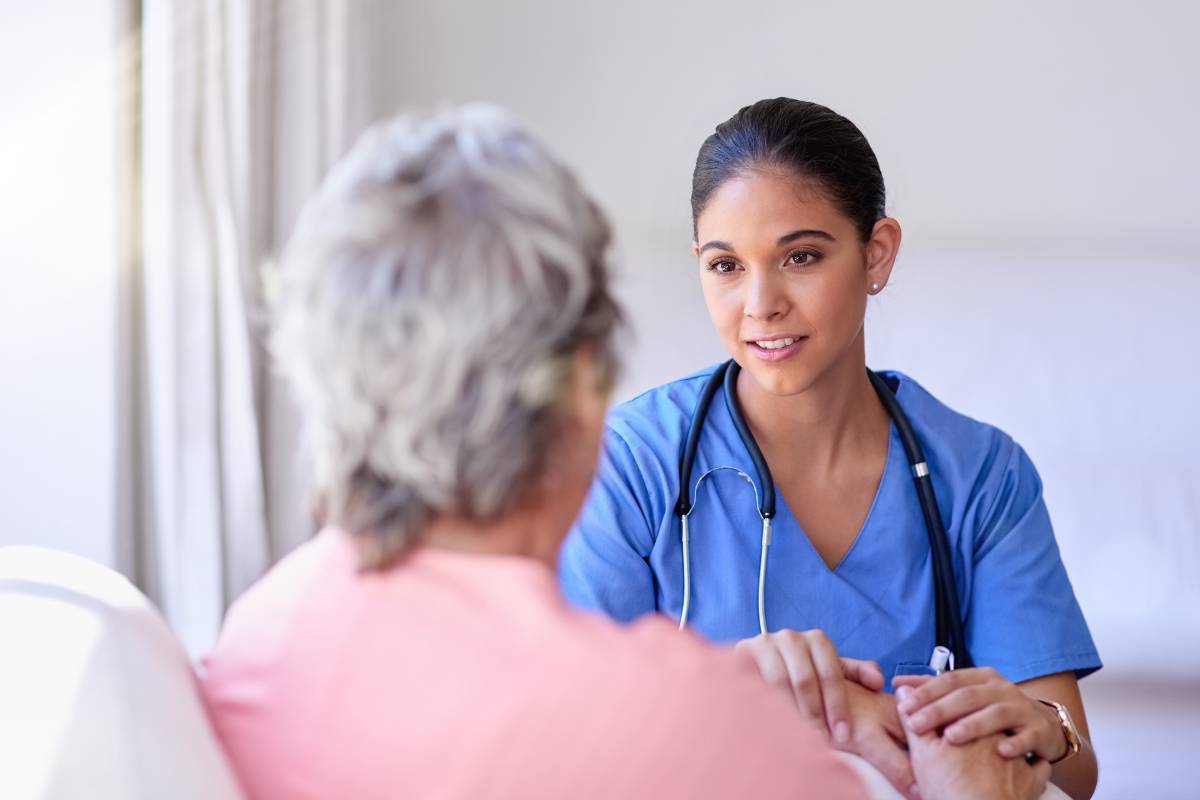 A nurse speaks with a resident in a recuperative care facility.
