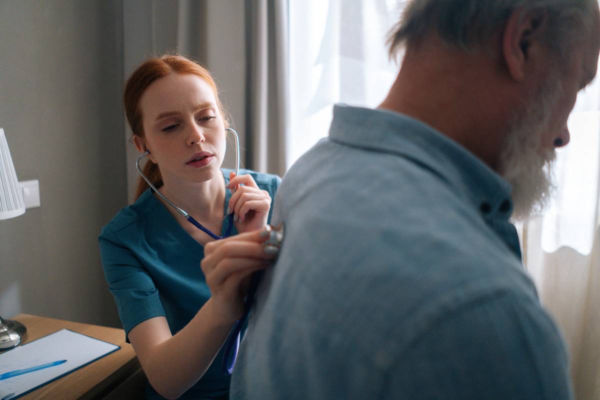 A respiratory nurse checks a patient's lung sounds.