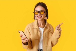 Woman on a yellow background wearing blue-light-blocking eyeglasses.